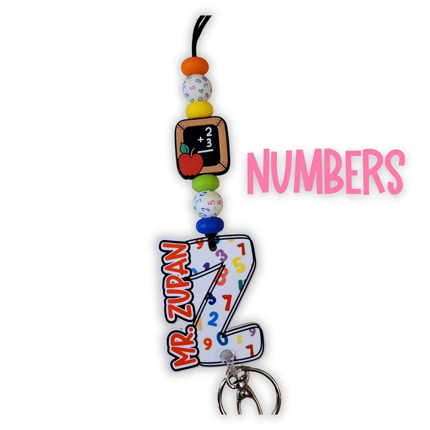 Mommie Peas Creations math teacher lanyard with acrylic charms featuring a chalkboard, apple, and a large 'Z' with numbers. Includes text 'MR. ZUPAN'.