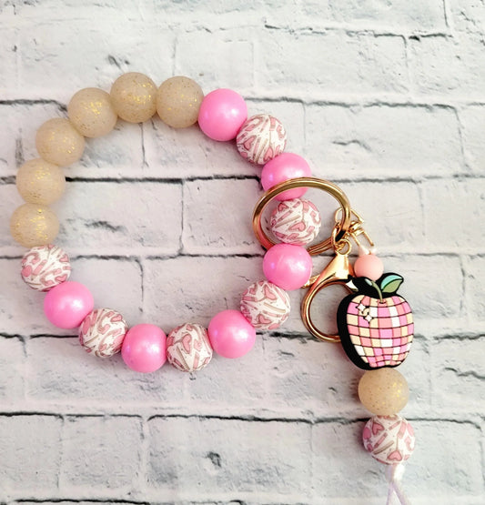 Mommie Peas Creations pink and gold beaded wristlet keychain with a pink apple charm and gold hardware.