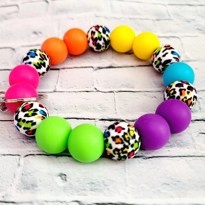 Mommie Peas Creations rainbow leopard print silicone beaded wristlet keychain with bright pink, orange, yellow, lime green, purple, and turquoise beads.