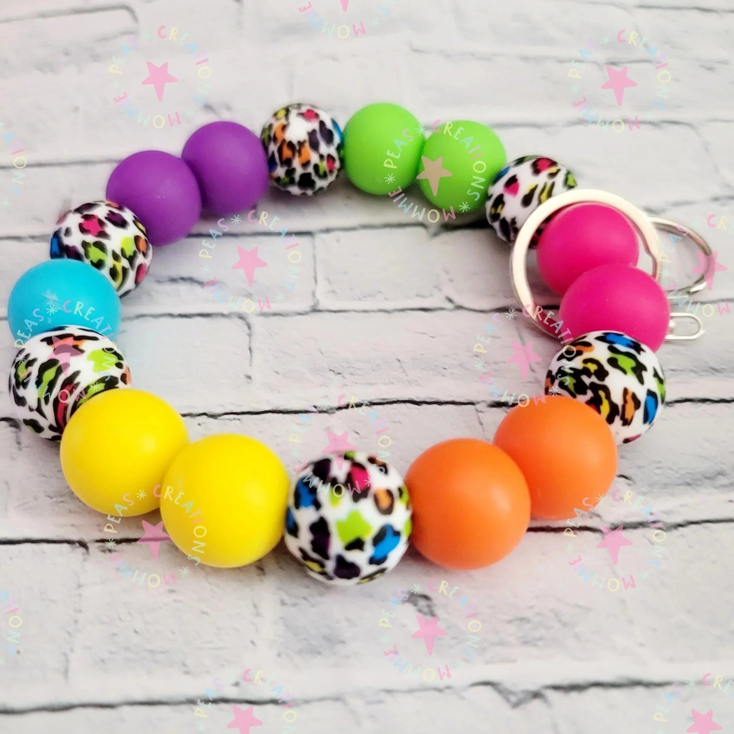 Mommie Peas Creations rainbow leopard print silicone beaded wristlet keychain with bright solid color beads and silver hardware.