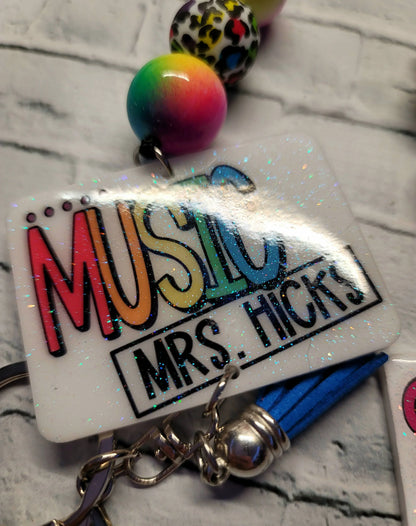 Mommie Peas Creations Music Teacher Mrs. Hicks badge holder with rainbow leopard print beads and blue tassel.