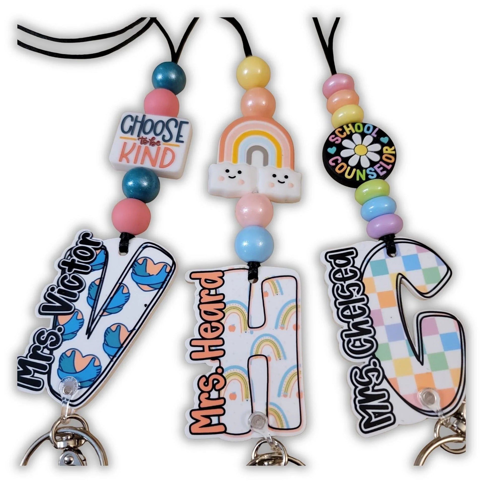 Mommie Peas Creations school counselor lanyards with custom acrylic name badges, colorful beads, and safety breakaway clasps. Features include 'Choose to be Kind' and rainbow charms.