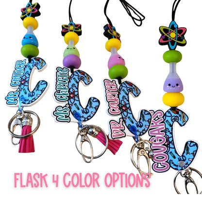 Mommie Peas Creations science lanyard with colorful beads, atom charm, and personalized acrylic initial featuring science icons. Includes breakaway clasp and tassel.