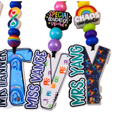 Mommie Peas Creations custom special education teacher lanyard with personalized acrylic letters spelling out names and featuring designs like Neuro Rainbow and SPED Squad.