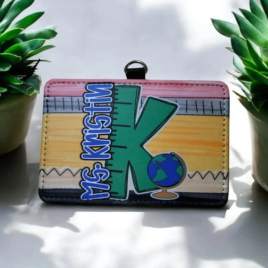 Mommie Peas Creations horizontal PU leather teacher badge holder with 'Ms. Kristin K' and a globe design.