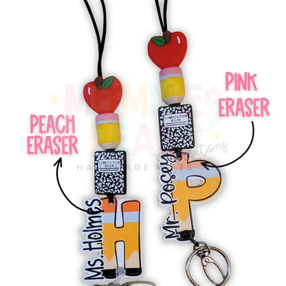 Mommie Peas Creations personalized teacher lanyard with apple, pencil, and composition book beads, and custom letter charm. Features a breakaway clasp.