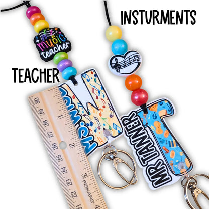 Mommie Peas Creations personalized teacher lanyard with colorful silicone beads, music notes, and custom acrylic charms for Mr. Tanner.