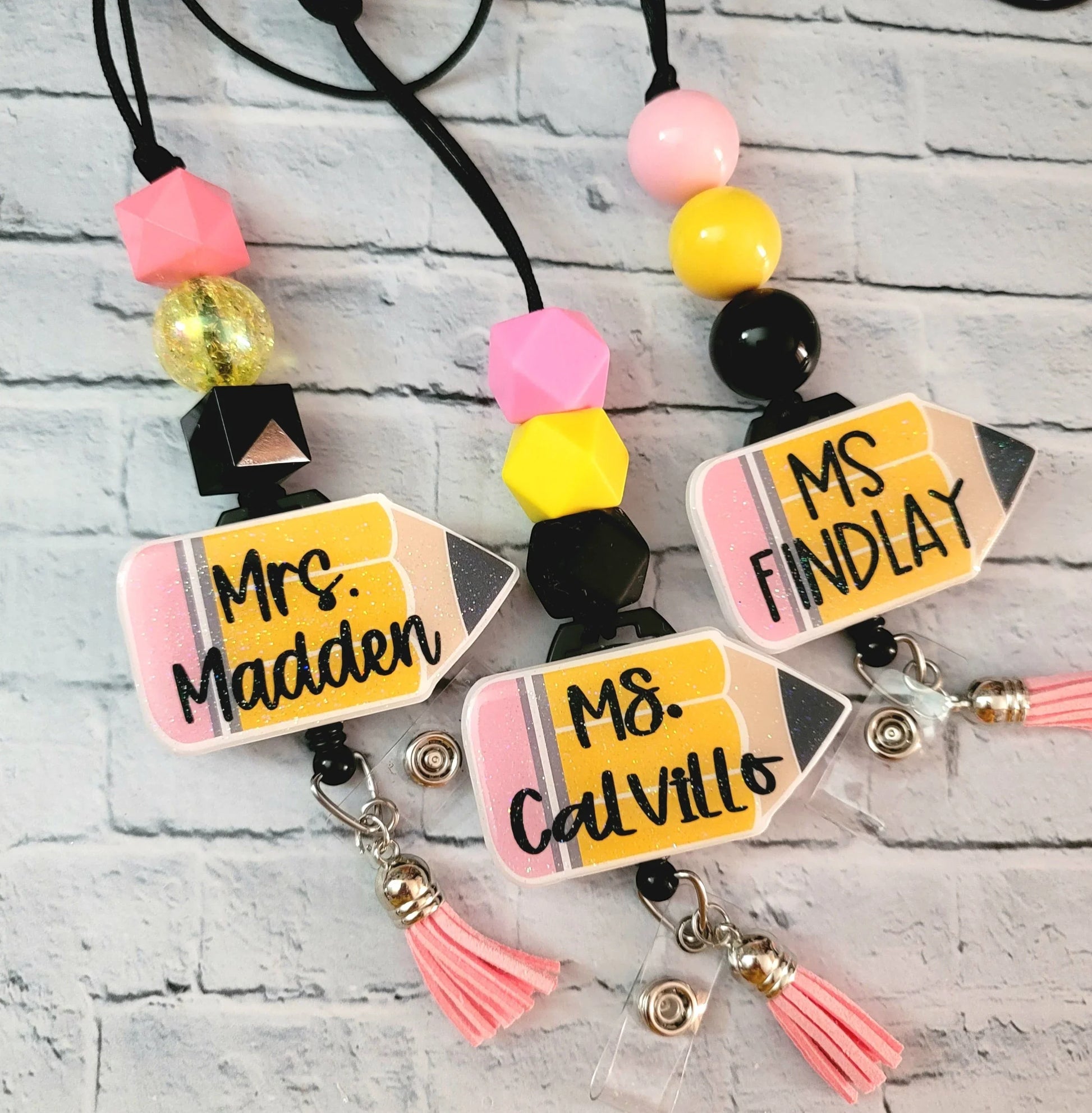 Mommie Peas Creations personalized teacher lanyard with glitter acrylic pencil charm, pink and yellow beads, and retractable badge reel.