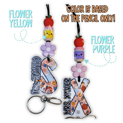 Mommie Peas Creations personalized teacher lanyard with silicone beads, acrylic charm, and breakaway clasp. Features school-themed designs.