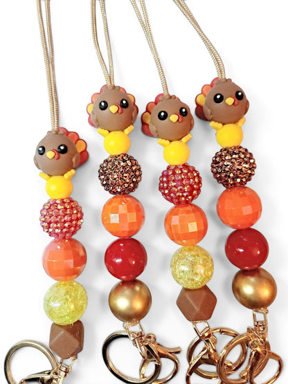 Mommie Peas Creations Thanksgiving turkey beaded lanyard with fall-colored beads and gold hardware. Features a 3D turkey charm and breakaway clasp.