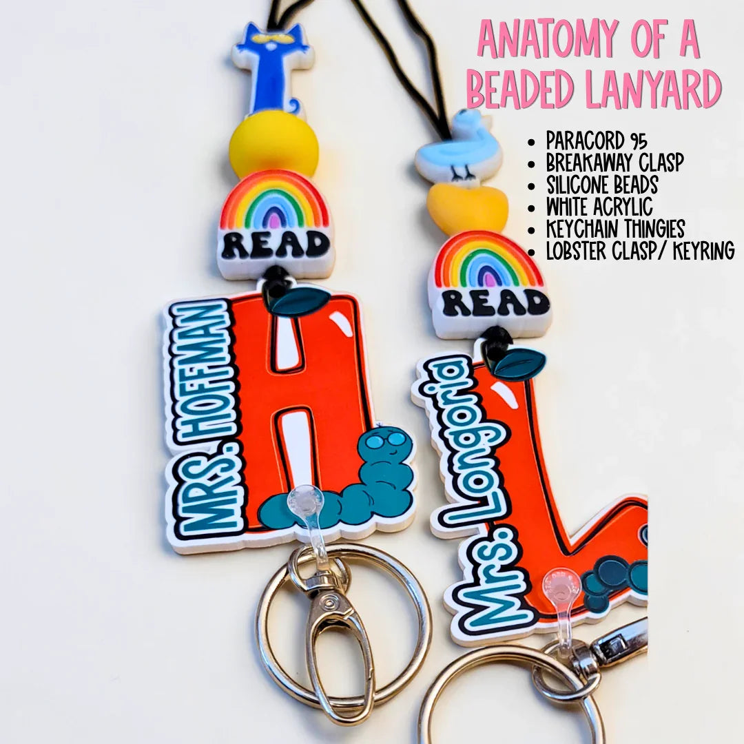 Colorful handmade beaded lanyards with red acrylic initials, rainbow charms, and custom teacher names.