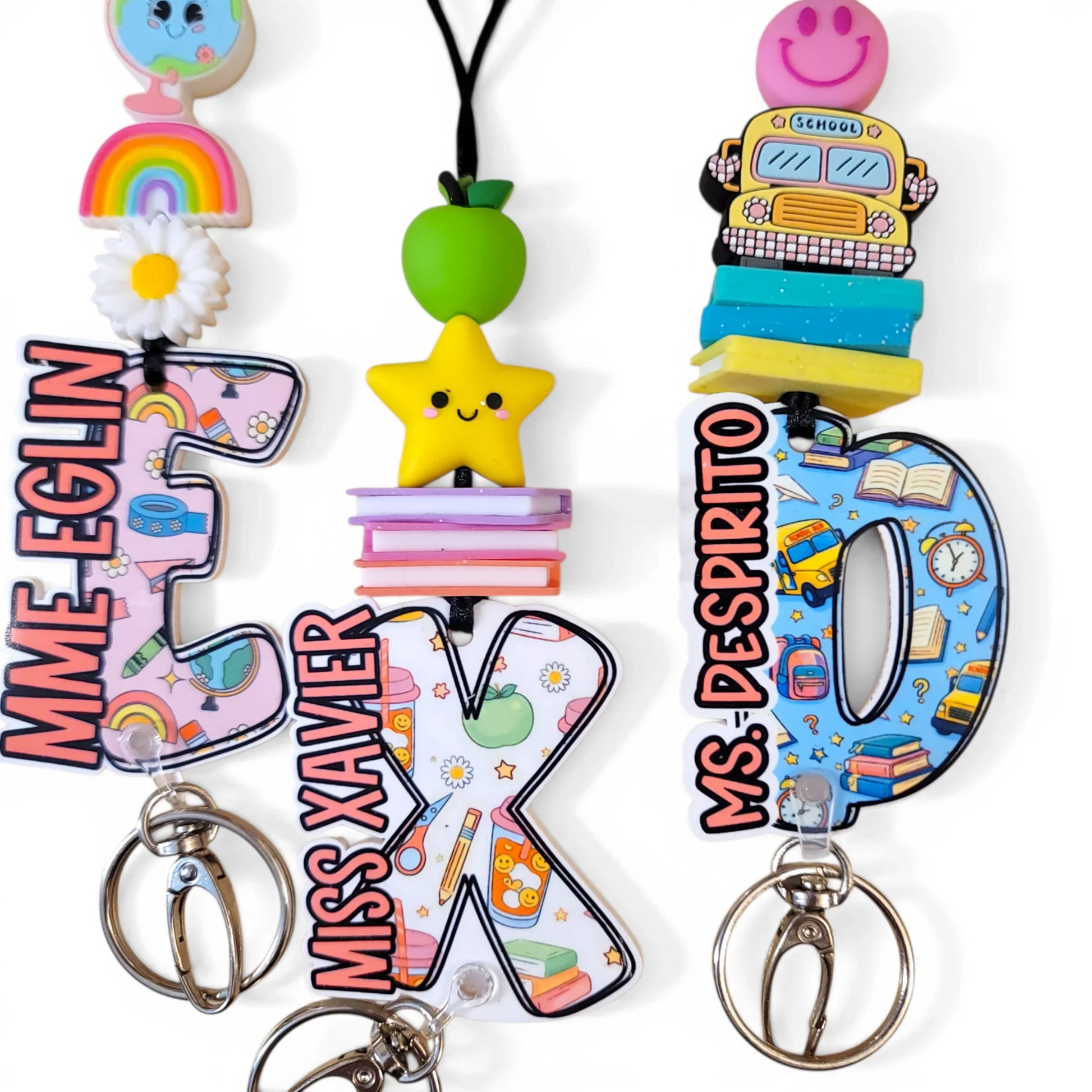Colorful handmade teacher keychains with cute charms, rainbow, star, apple, and bus designs.