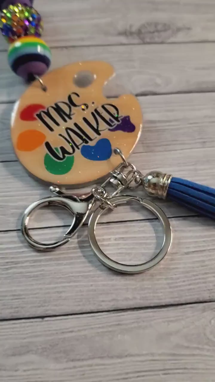 Close up video showing the glossy resin finish and vibrant rainbow beads of the personalized art palette lanyard | Id Holder for teachers | Art